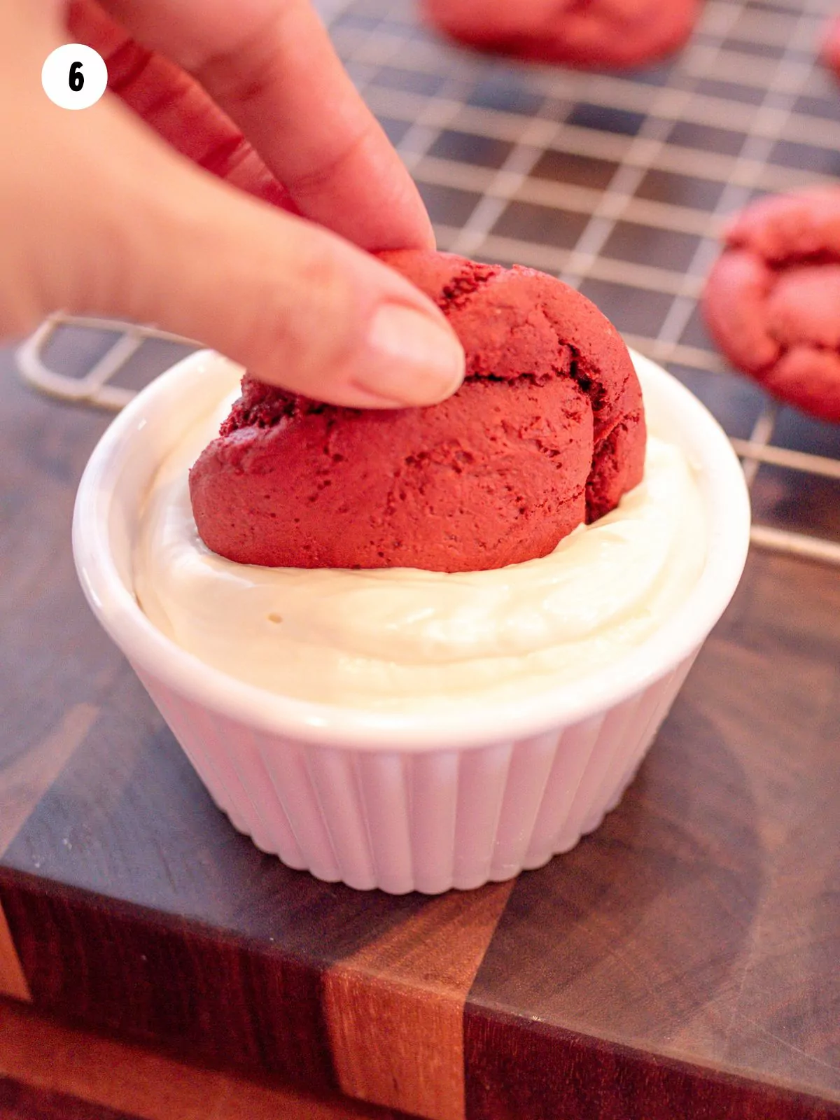 Cookie dipping into melted white chocolate.