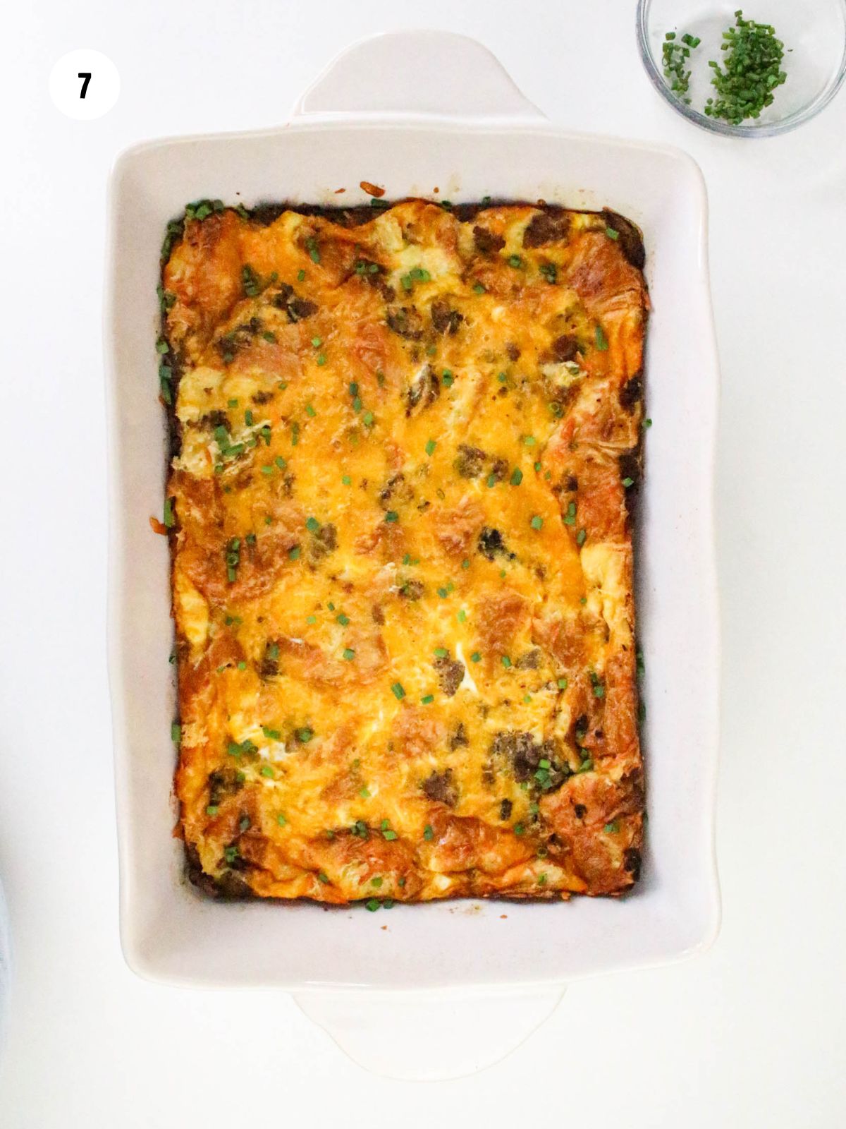 Baked breakfast casserole with fresh chives on top.