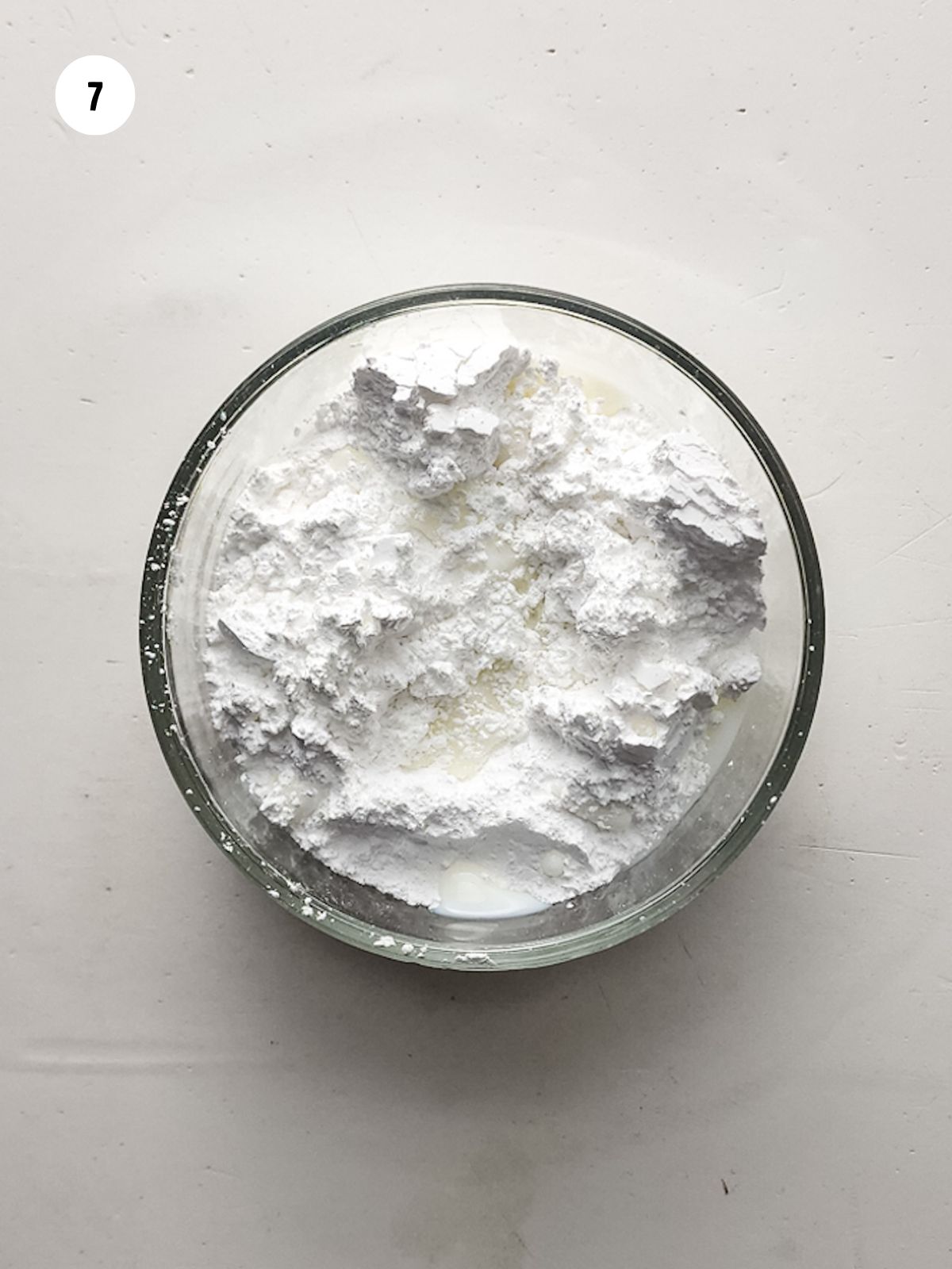 Powdered sugar and milk in a small mixing bowl.