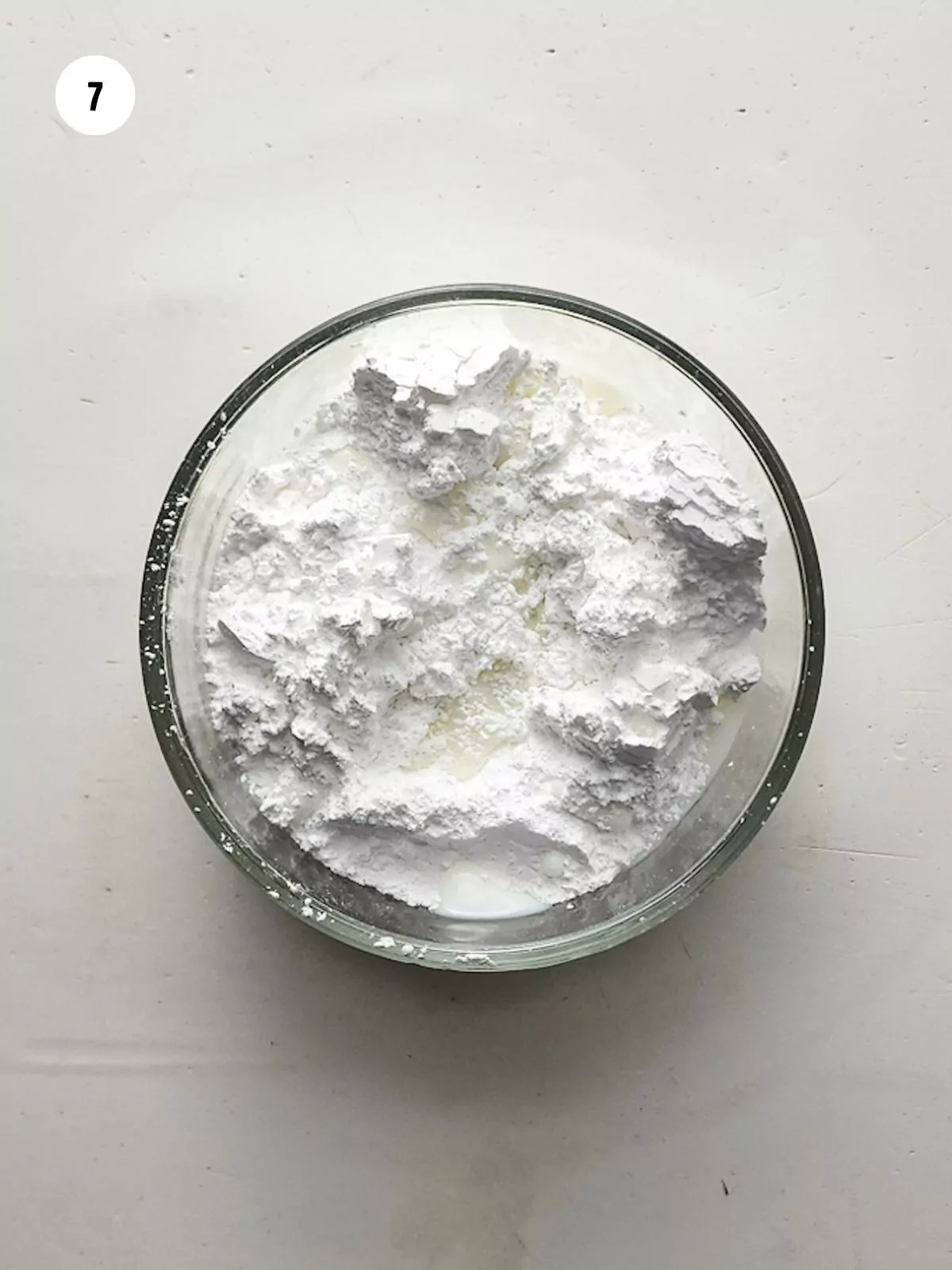 Powdered sugar and milk in a small mixing bowl.