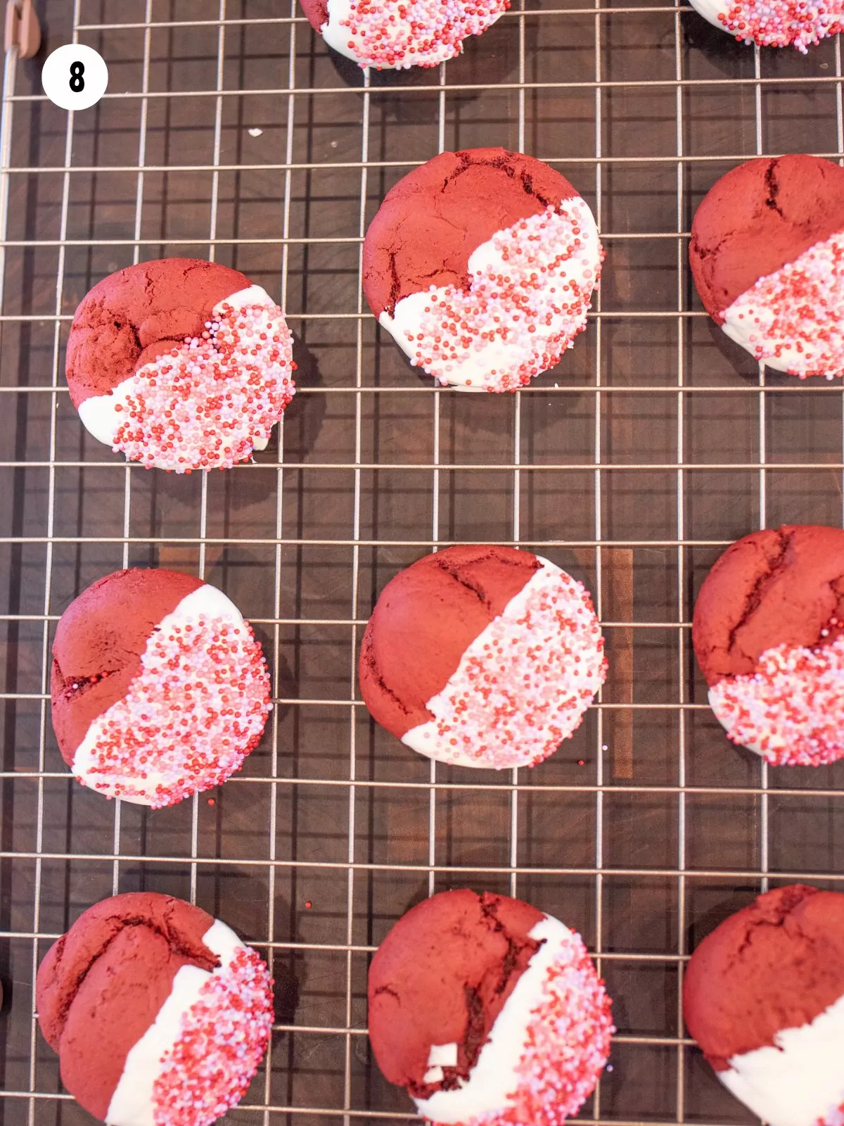 Chocolate and sprinkle dipped cake mix cookies drying on a rack.