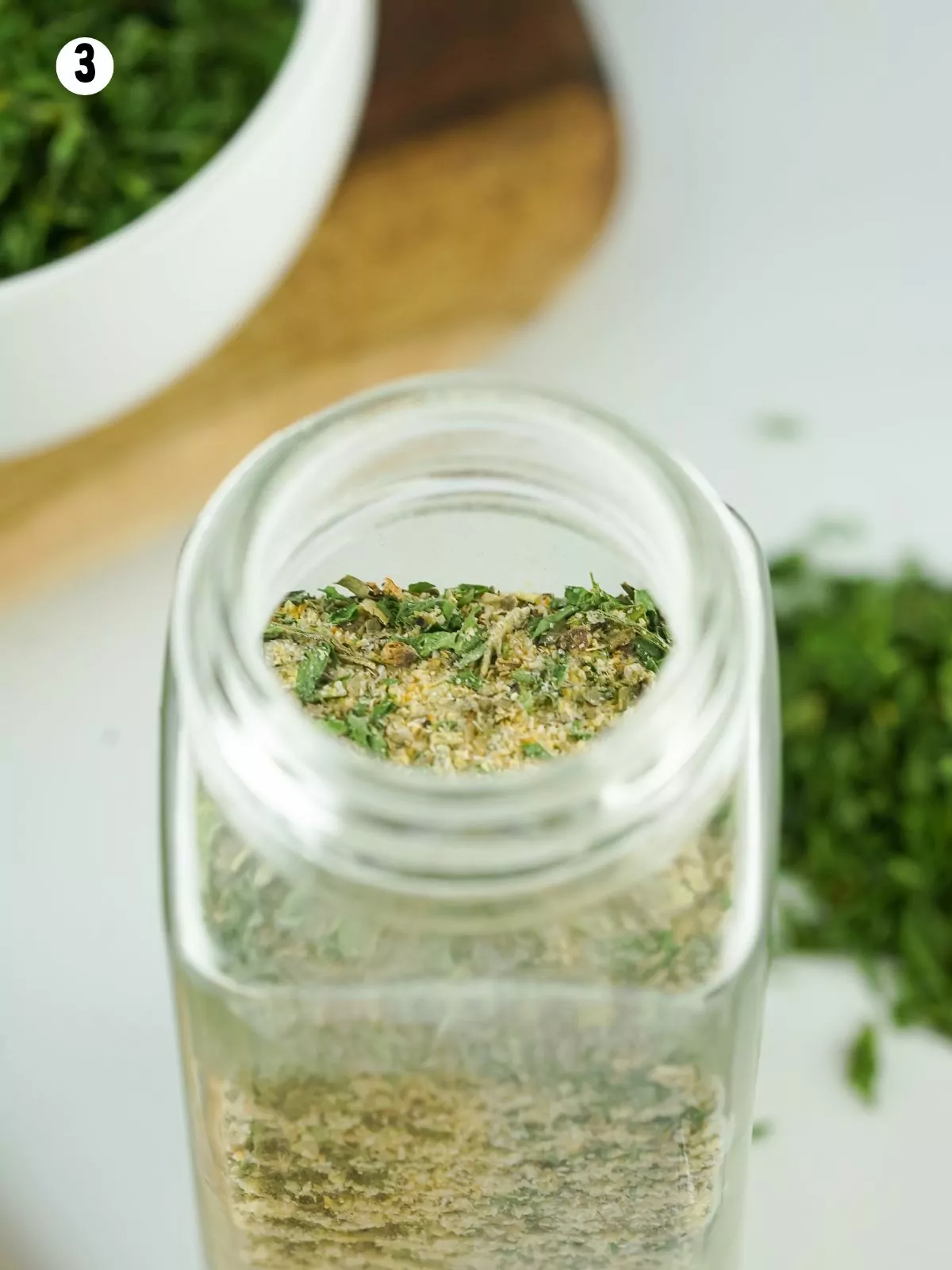 overhead view into a glass bottle of homemade seasoning mix.