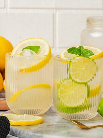 2 glasses of lemon lime water with fresh mint and fresh fruit slices.