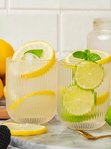 2 glasses of lemon lime water with fresh mint and fresh fruit slices.