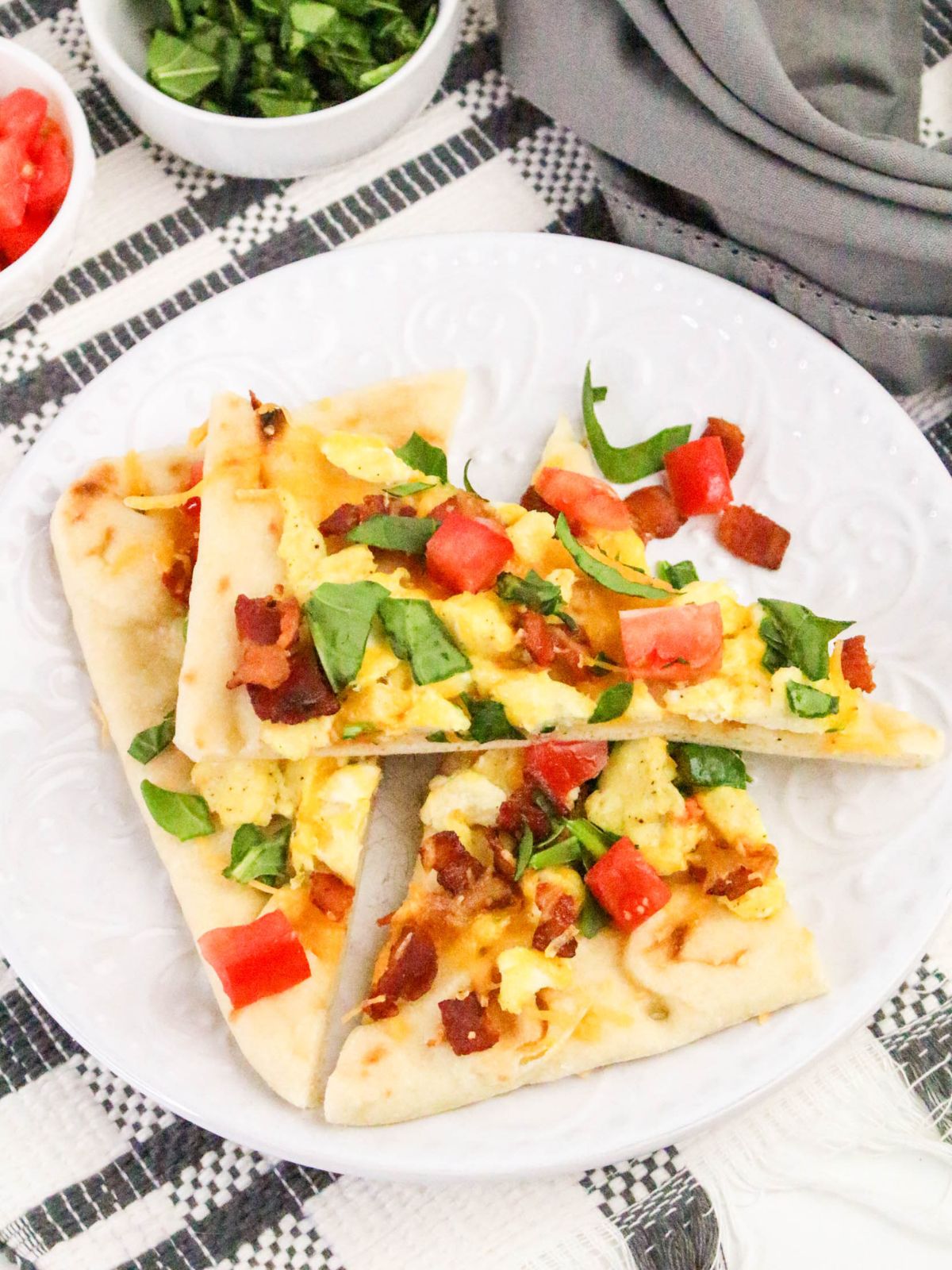 Breakfast Flatbread with scrambled eggs, bacon, and cheddar cheese.