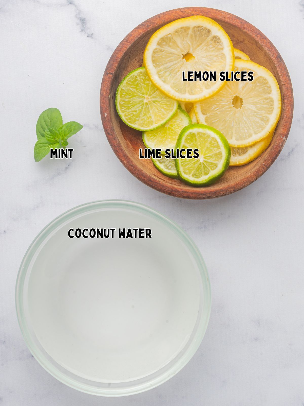 ingredients for coconut water with lemon and lime slices and mint.