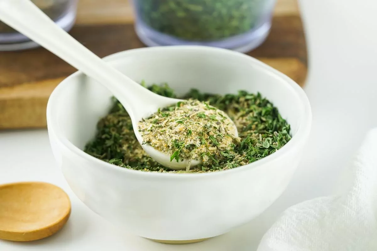 small bowl with homemade dried seasoning mix with small white spoon.