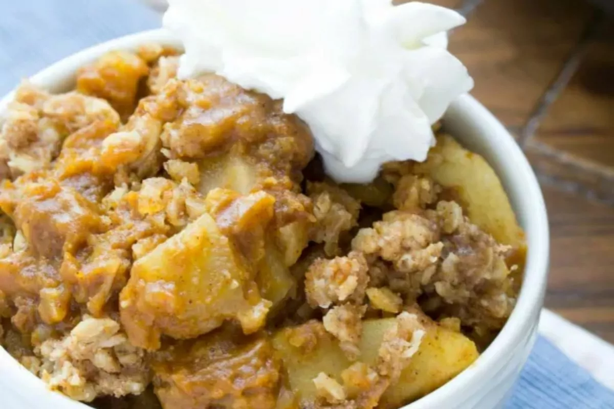 bowl of Pumpkin Apple Crisp with whip cream on top