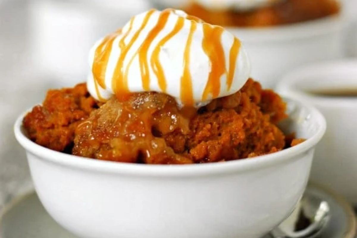 bowl of Pumpkin Cobbler with whipped cream and caramel on top