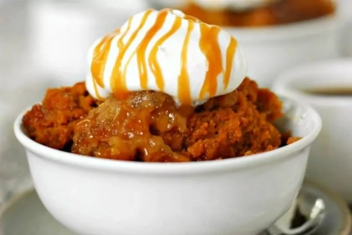 bowl of Pumpkin Cobbler with whipped cream and caramel on top