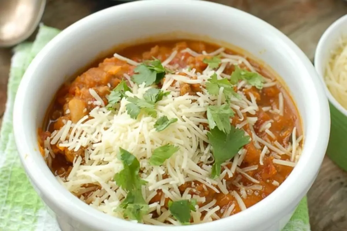 bowl Pumpkin White Bean Sausage Chili with cheese topping