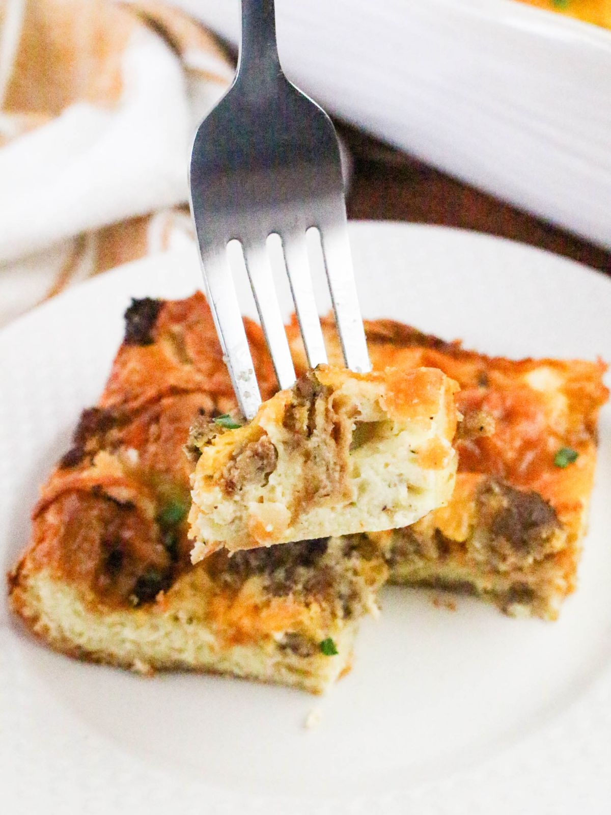 Fork taking a piece from the slice of casserole.