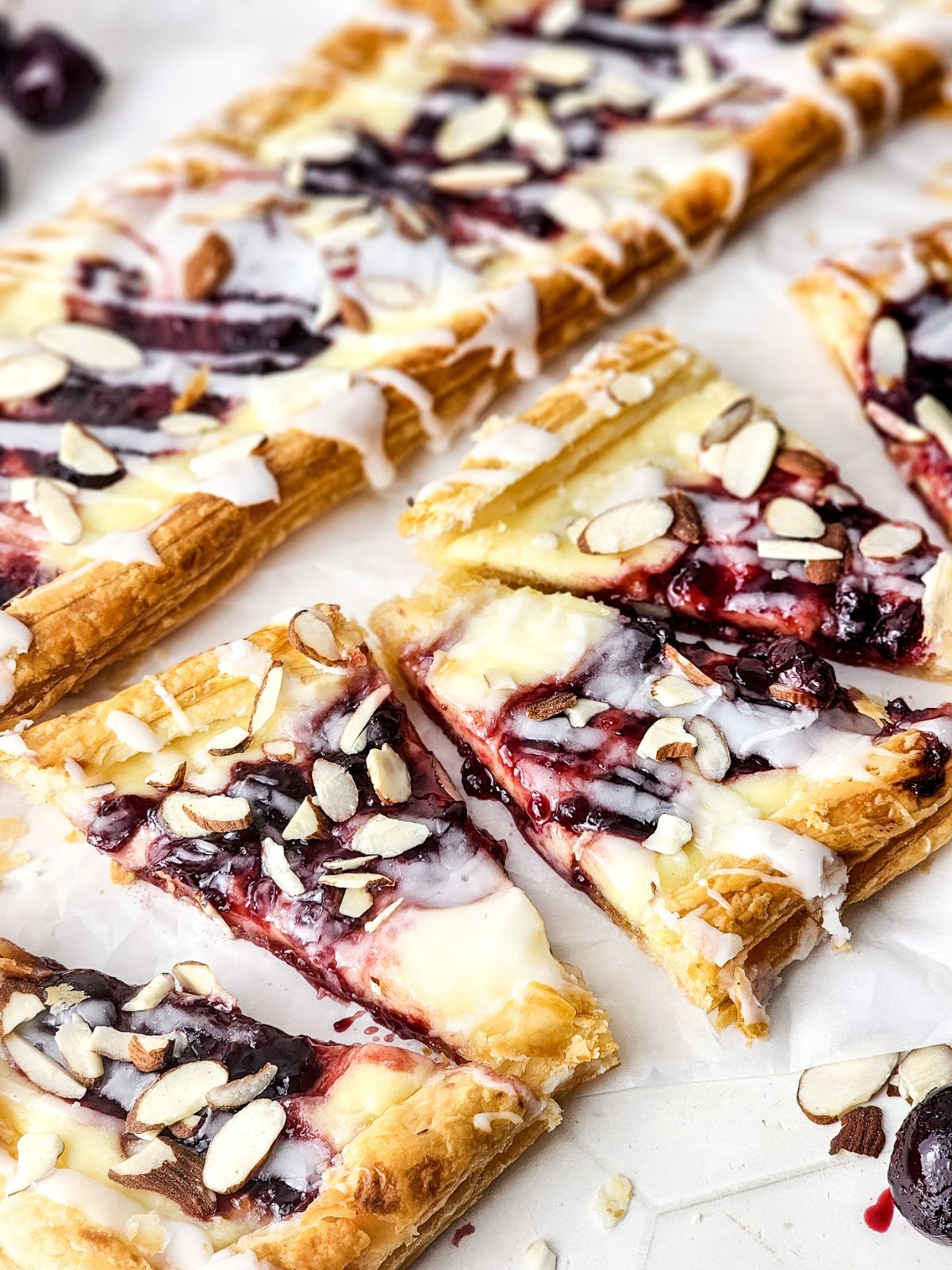 Puff pastry blueberry danish topped with glaze and sliced almonds.