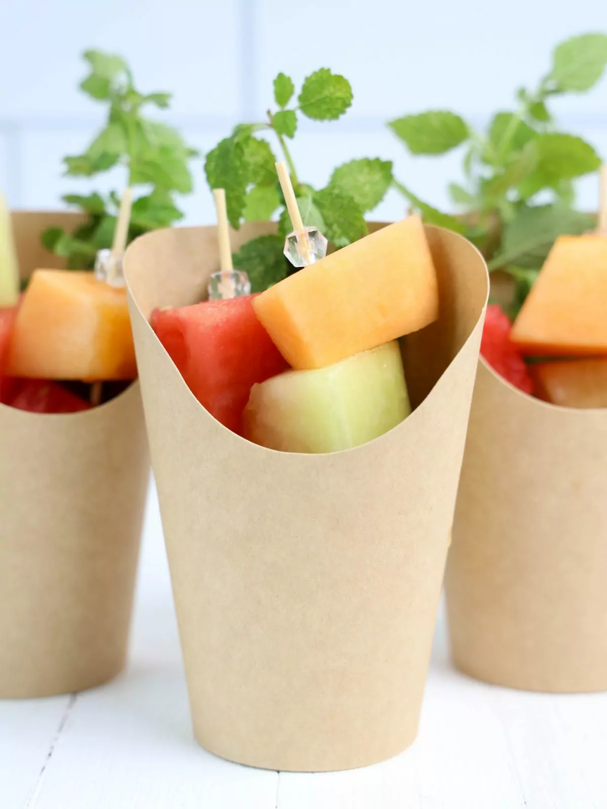 Charcuterie cups filled with skewers of melon.