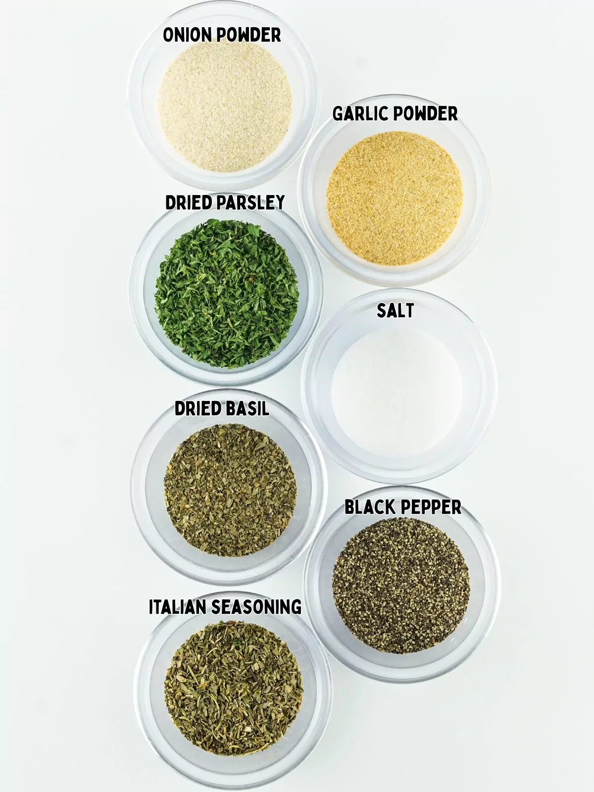 assorted dried herbs in small glass bowls.