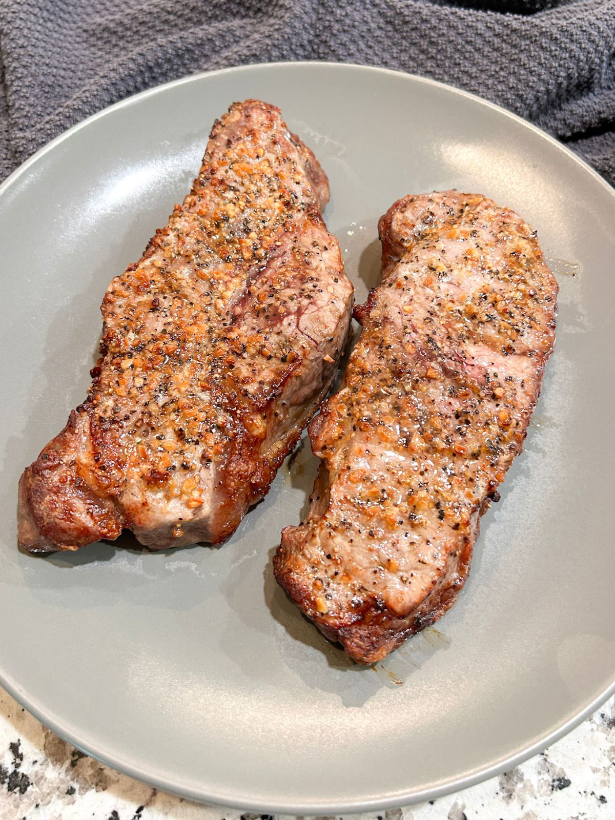 Two cooked New York Strip steaks.
