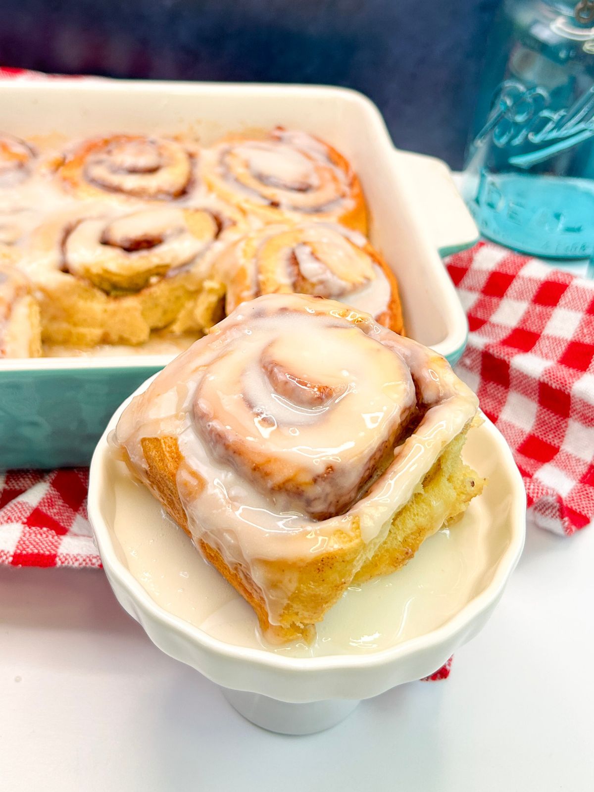 A big cinnamon roll with icing served.