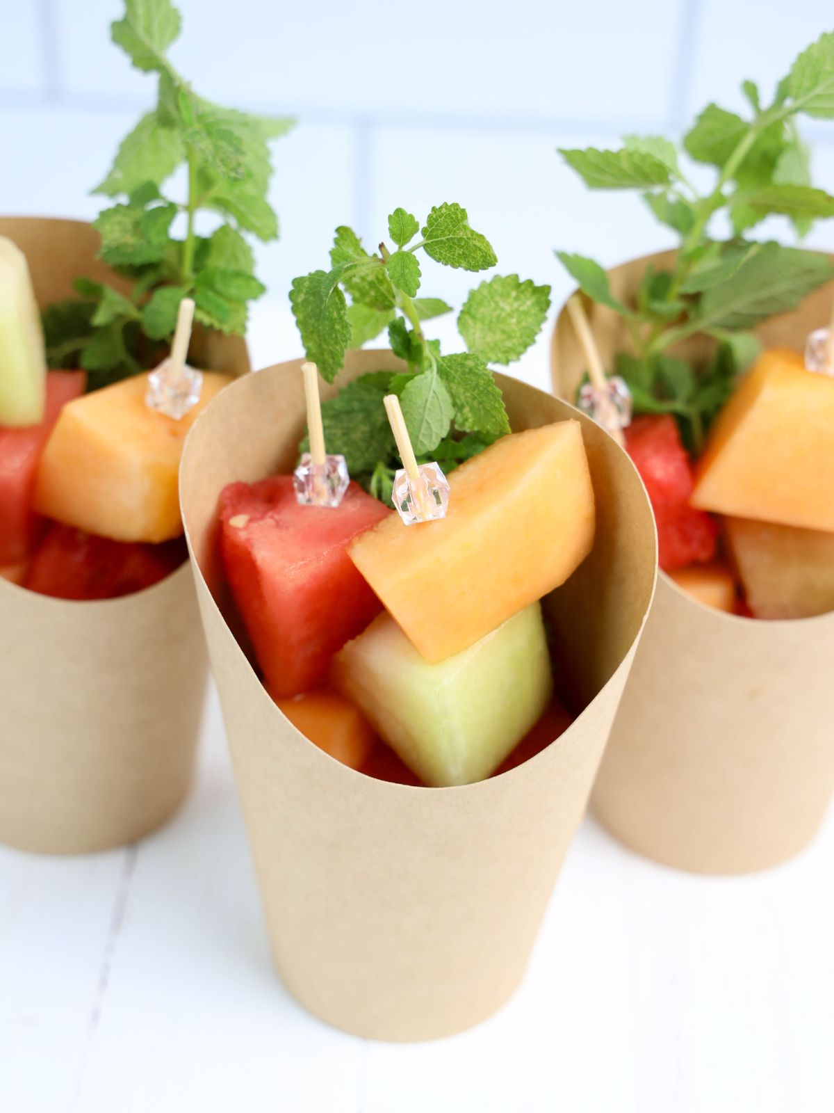 Overhead view of melon skewers in charcuterie cups.