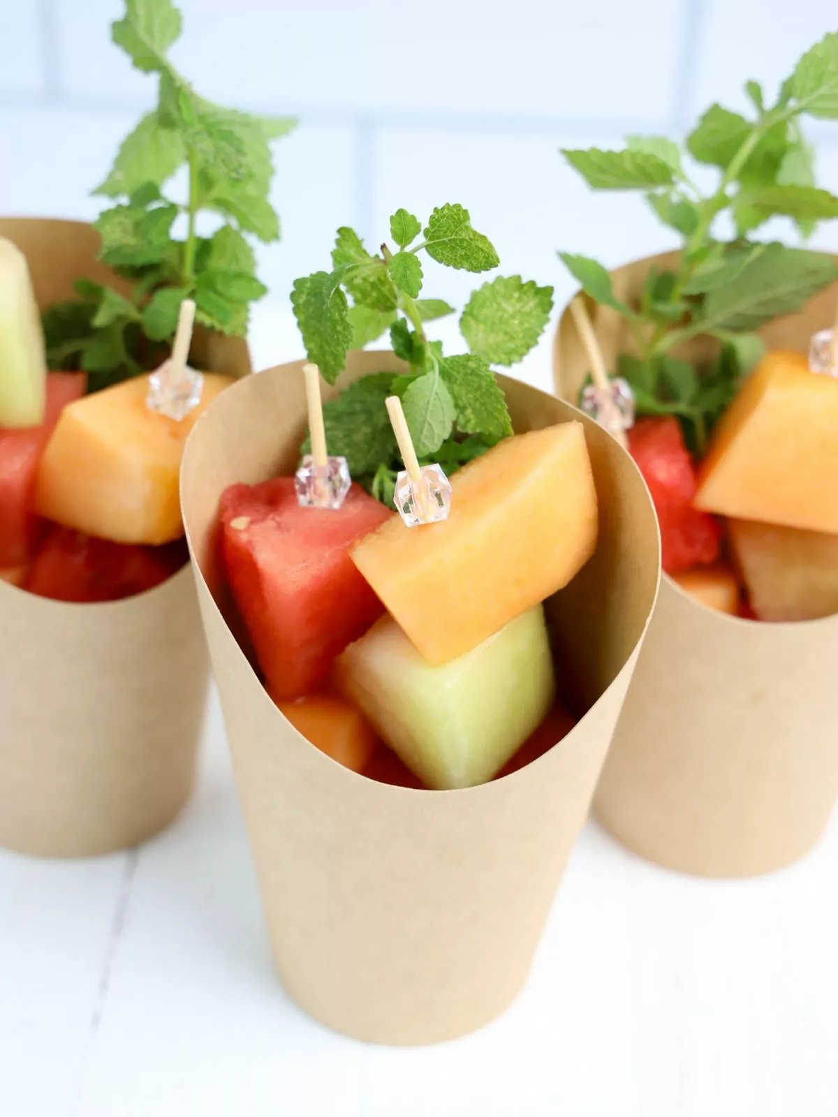 Overhead view of melon skewers in charcuterie cups.