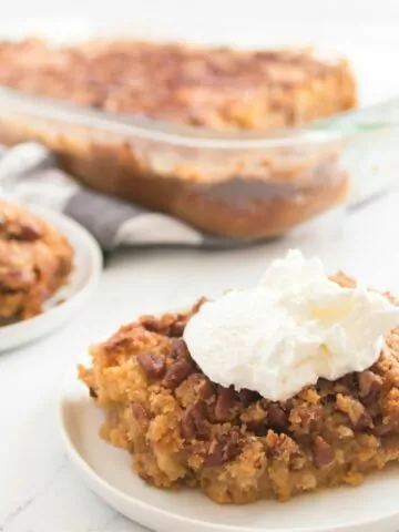 pumpkin cake made with cake mix on plate with whipped cream.