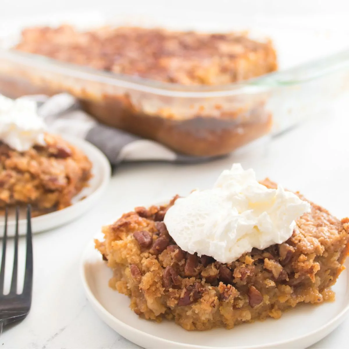 pumpkin cake made with cake mix on plate with whipped cream.