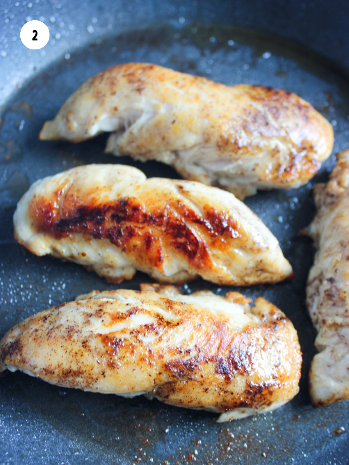 Chicken tenderloins cooking in a pan.