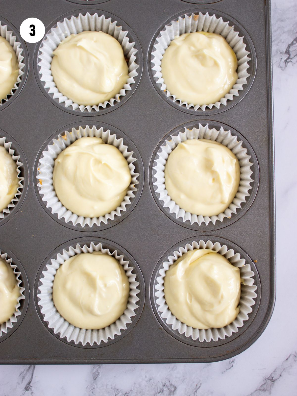Cream cheese filling added on top of the crusts in the muffin tin.