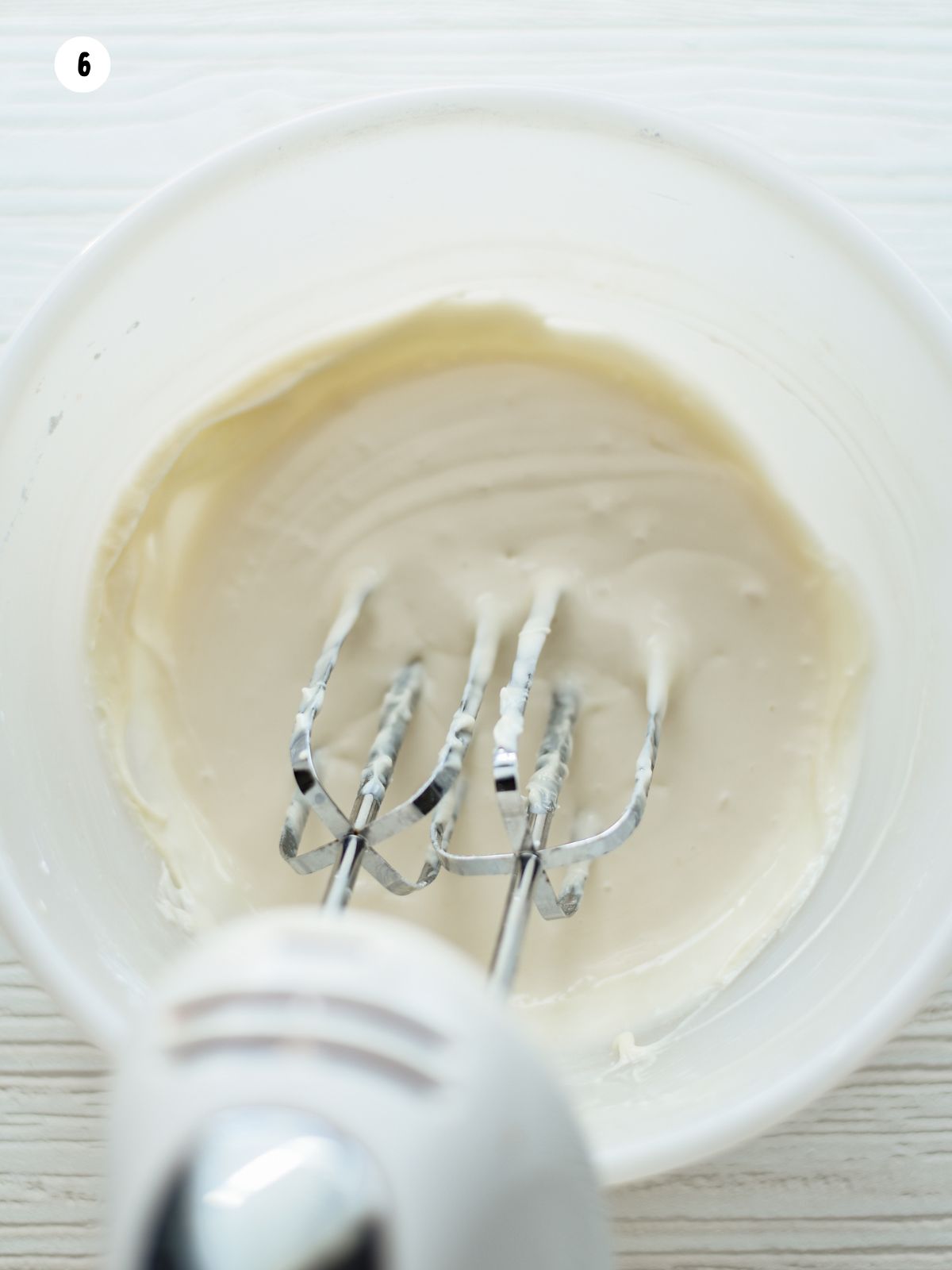 homemade cream cheese frosting being mixed with a hand mixer.