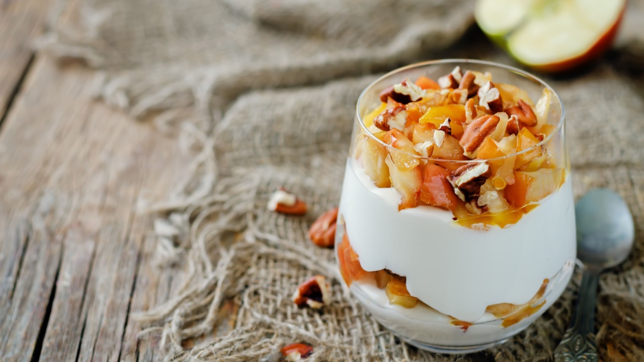 Caramelized apple pecan greek yogurt parfait in a glass. toning. selective focus
