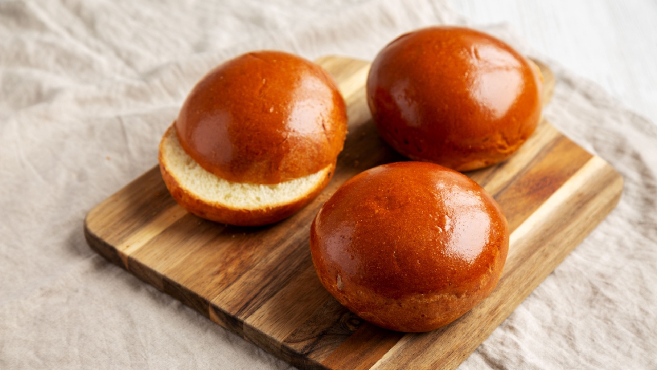 Homemade Brioche Hamburger Buns on a wooden board, side view.