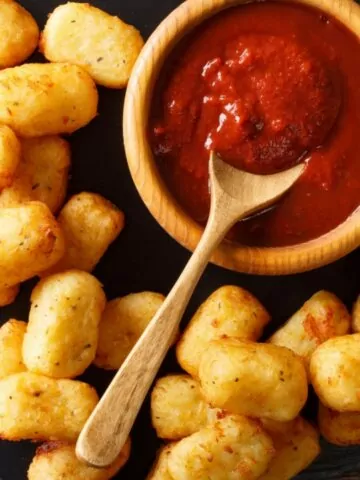 Homemade Tater Tots with tomato sauce close up on the table