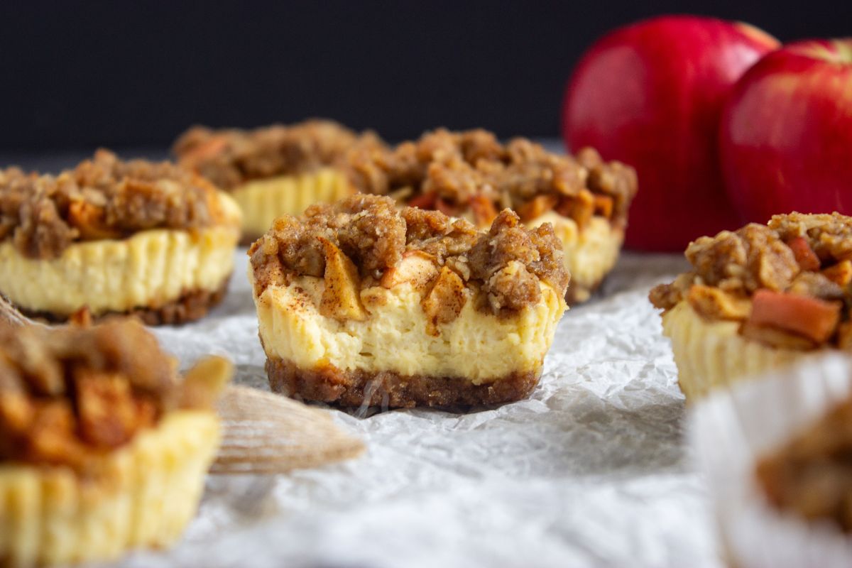 Mini cheesecakes with apple crumb topping. The one in the middle is cut in half.