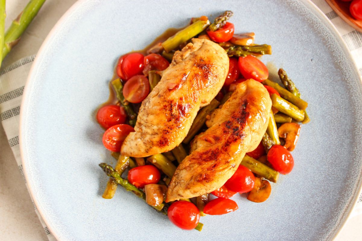 Two chicken tenderloins served over sautéed asparagus, tomatoes, and mushrooms.