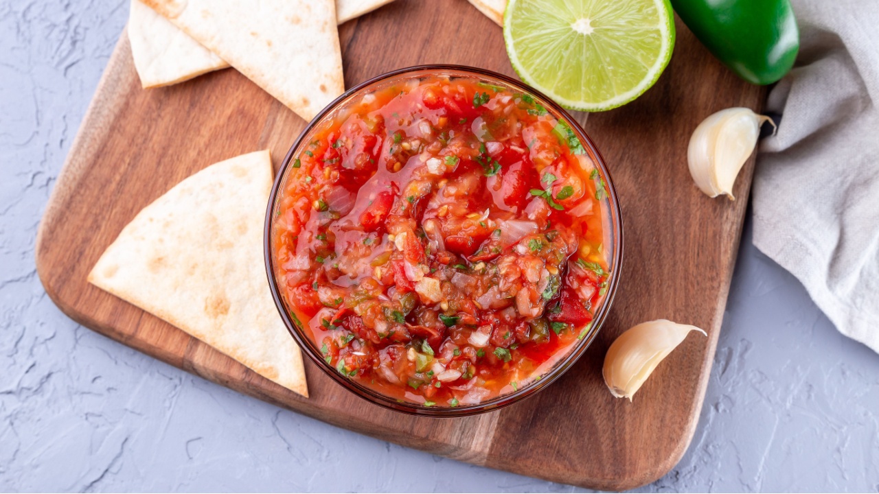 Traditional Tex-Mex cuisine salsa Asada sauce with roasted vegetables, served with a tortilla chips and lime, horizontal, top view