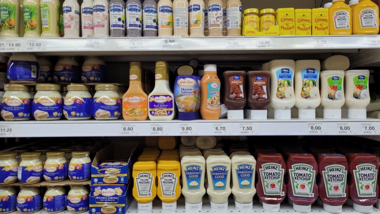 Various brands of mayonnaise, ketchup, chili, and BBQ sauce are displayed on the store shelves