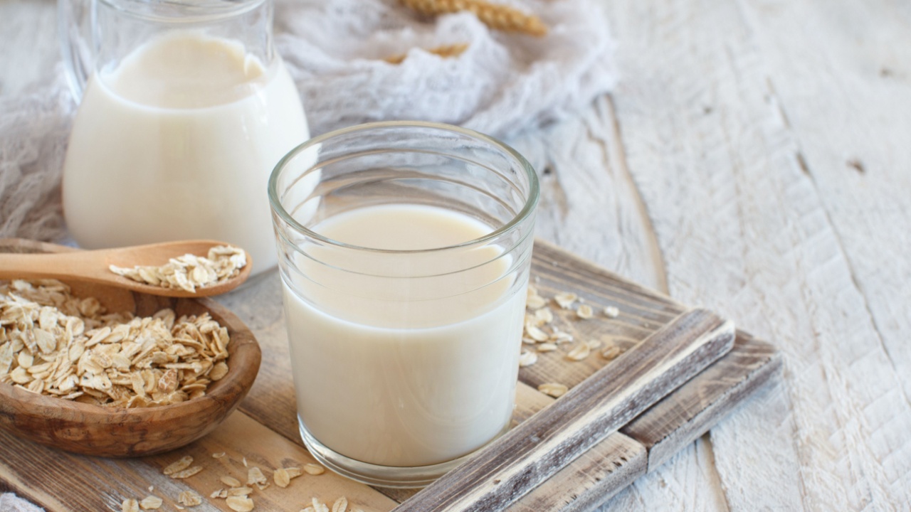 Vegan oat milk, non dairy alternative milk in a glass close up