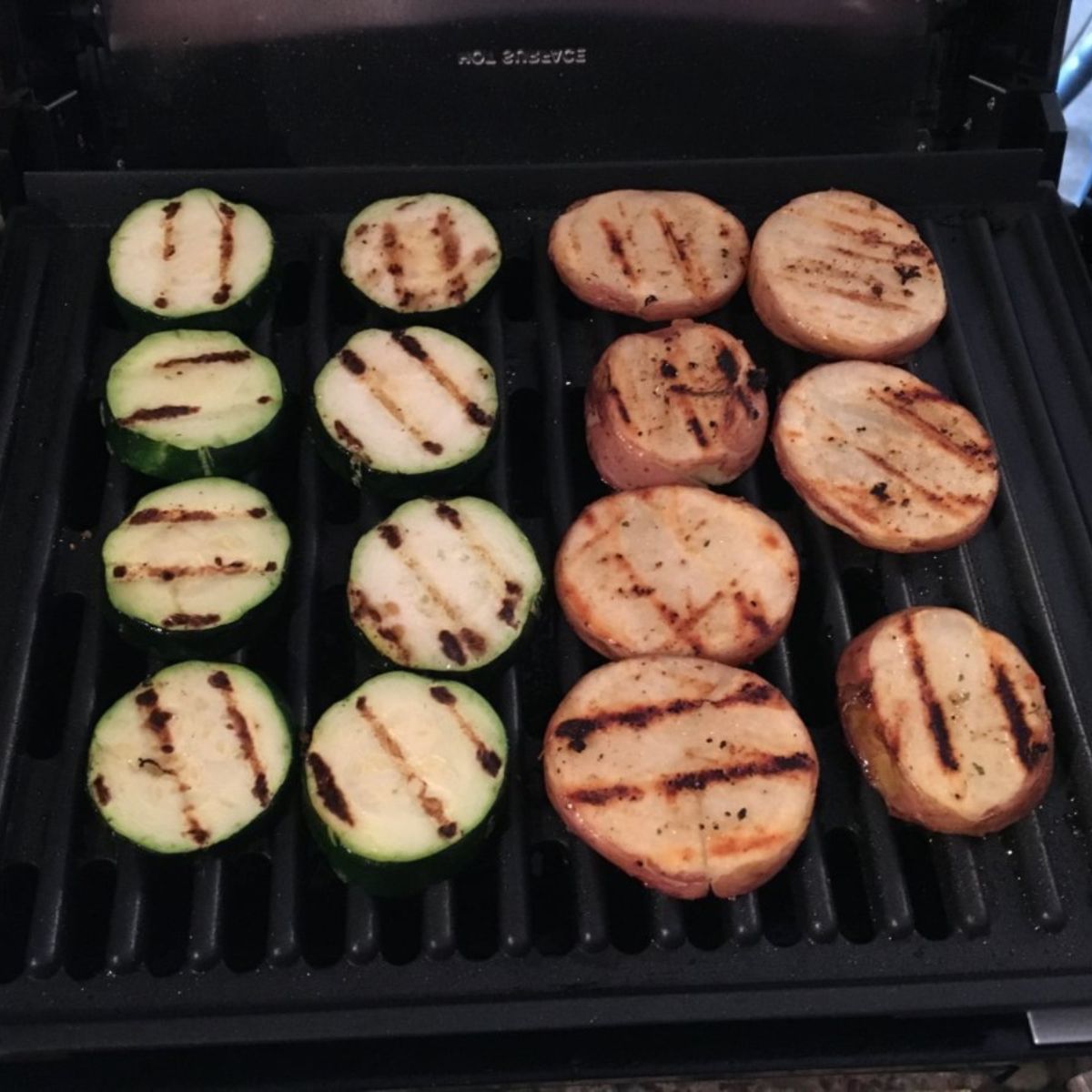 zucchini and red potatoes with grill marks on grill.