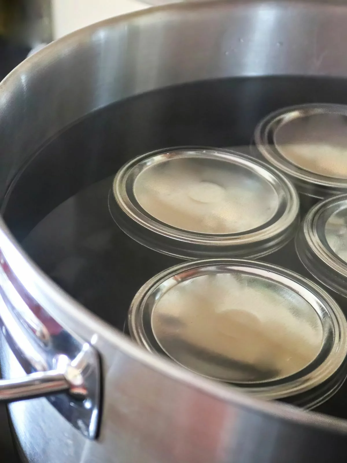 mason jars in stock pot with water.