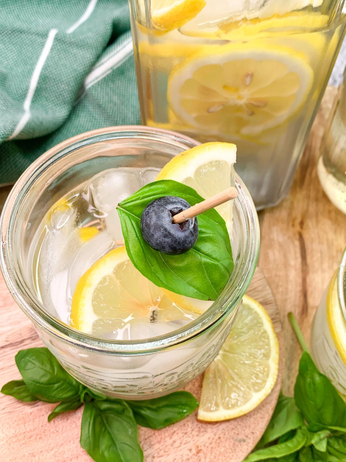 overhead view of spritzer with basil leaf, blueberry and lemon slices.