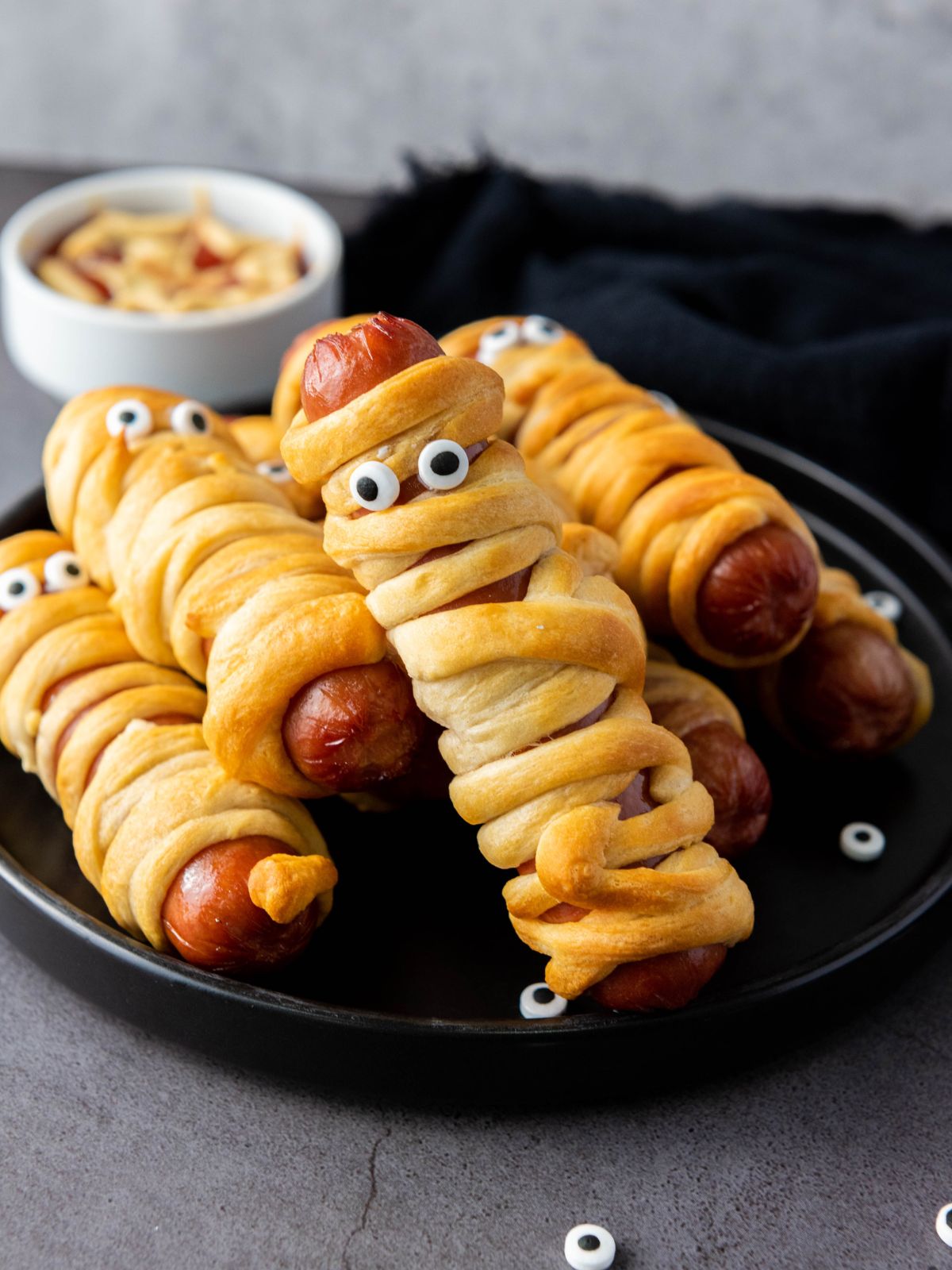 Hot dogs wrapped in crescent dough with edible eyes to look like mummies.