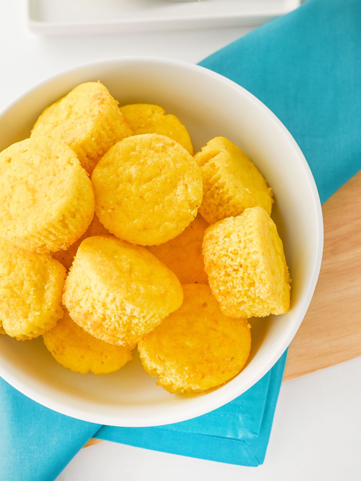 White bowl filled with cornbread muffins.