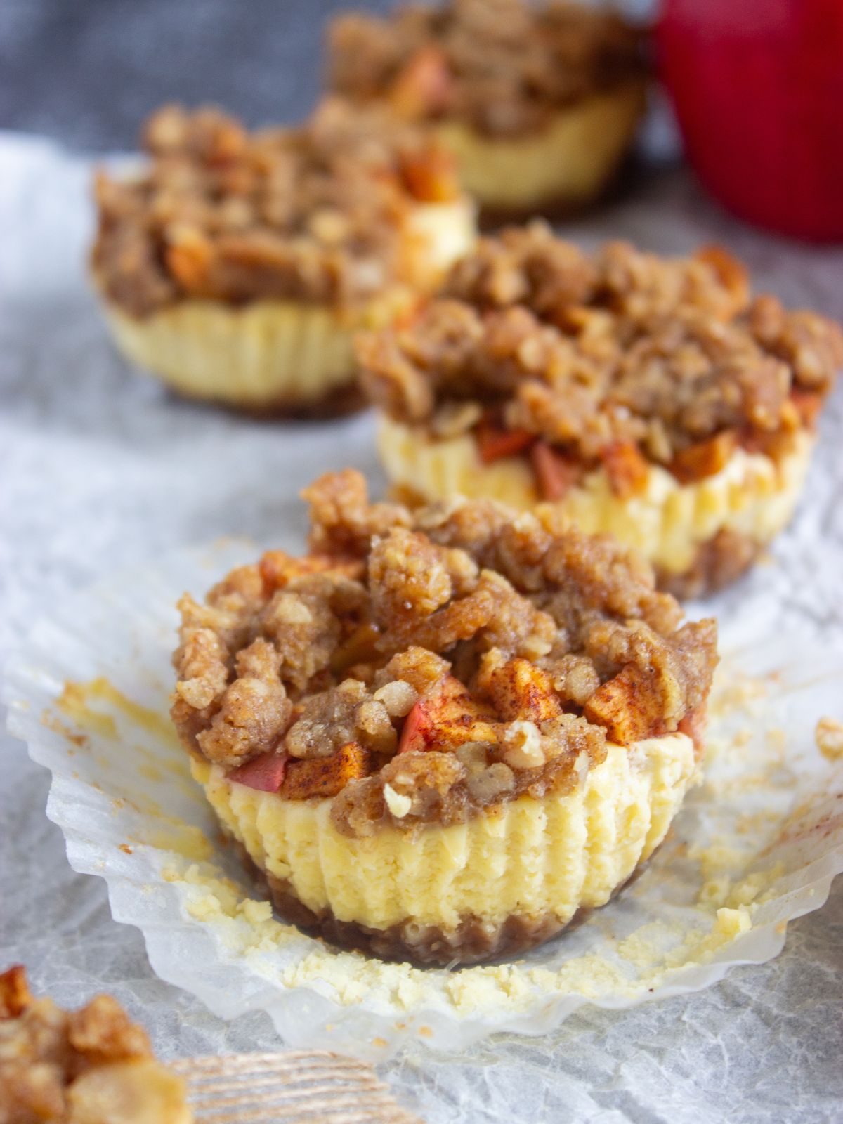 apple cheesecake cupcakes with the wrapper pulled away from them.