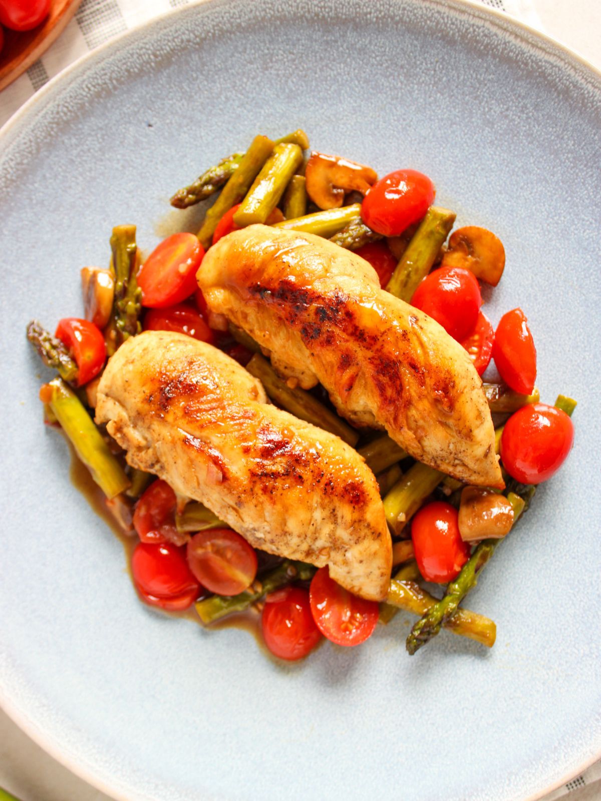 Chicken and veggies served on a light blue plate.