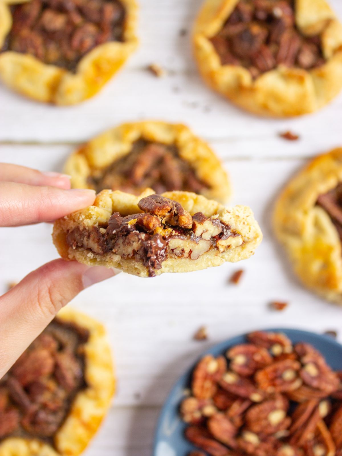Slice of pecan galette being held.