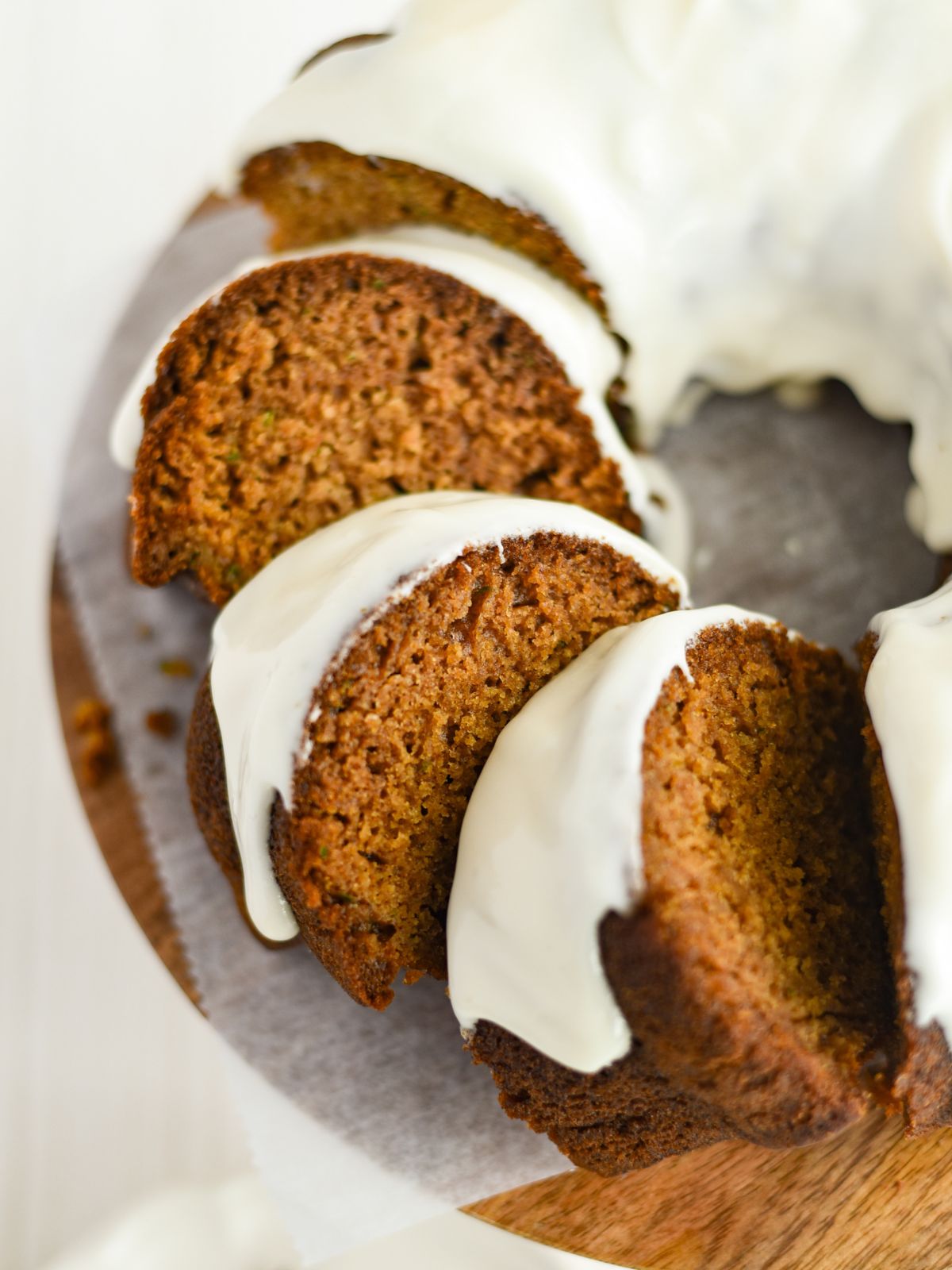 closeup of zucchini pumpkin bundt bread with frosting.