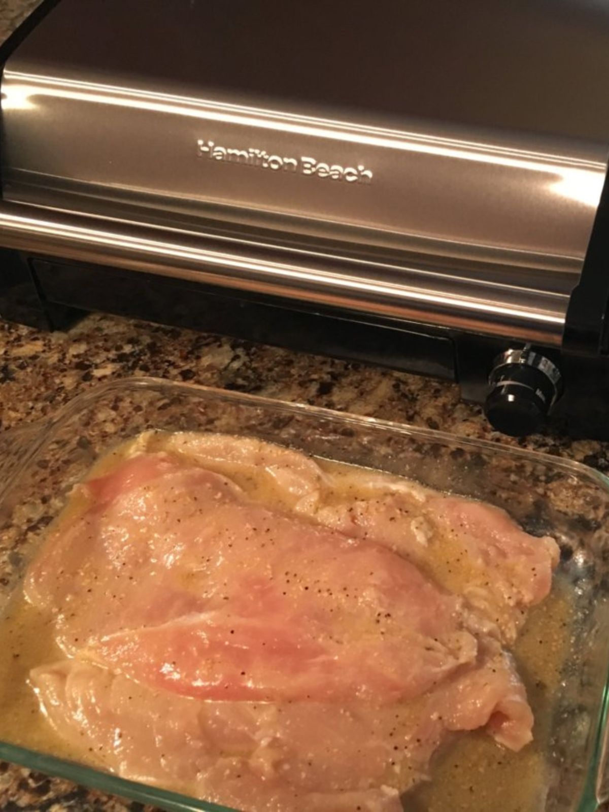 raw chicken in glass dish with Italian salad dressing. Hamilton Indoor Grill in background.