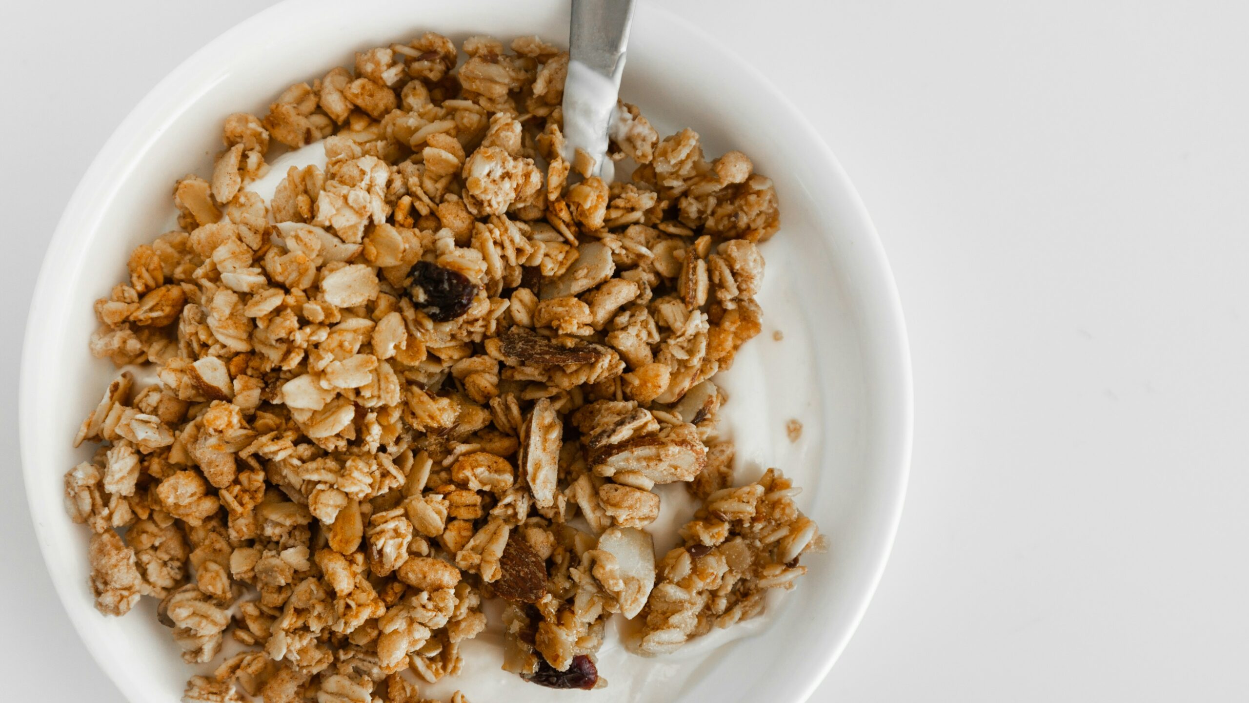 bowl of granola with milk and a spoon