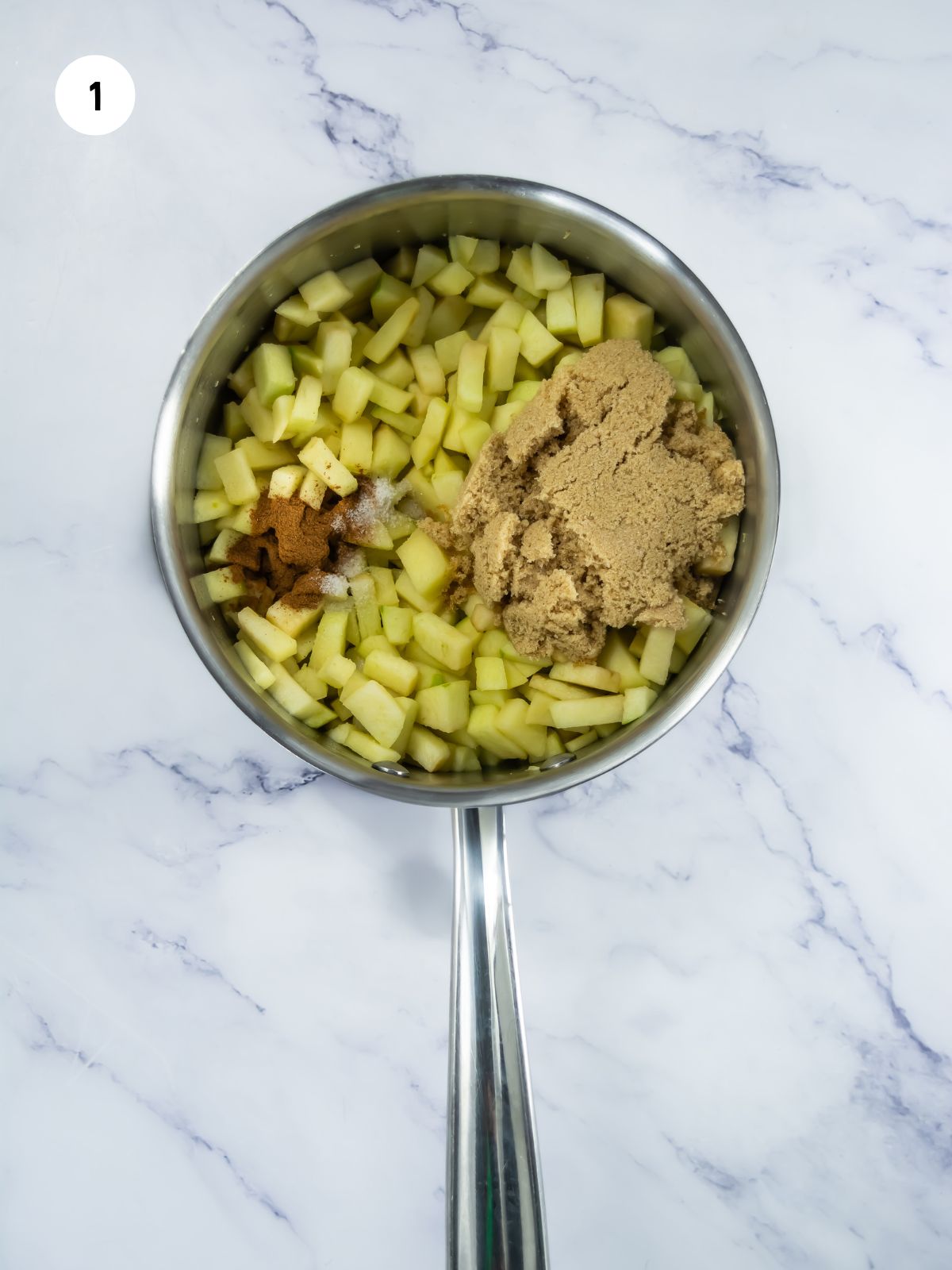 Saucepan filled with diced apples, brown sugar, cinnamon, salt, and melted butter.