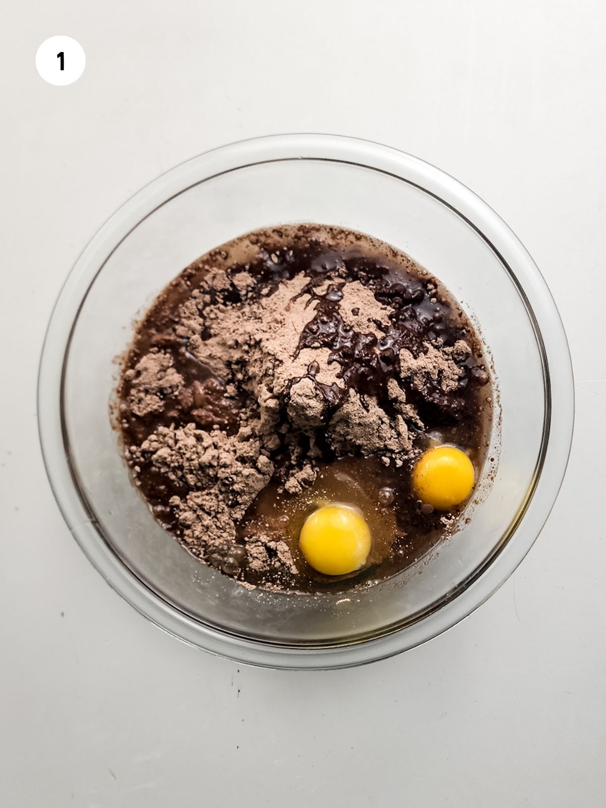 Brownie ingredients in a clear mixing bowl.