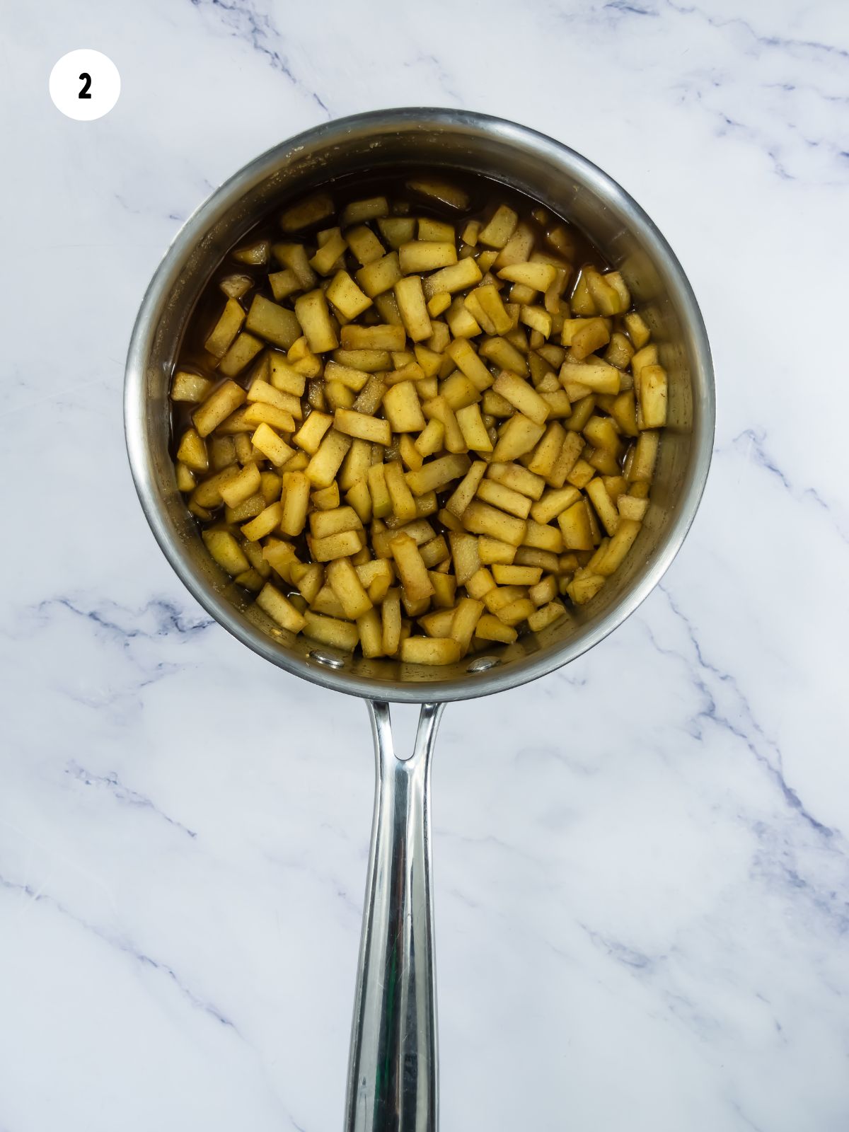 Saucepan filled with cooked apples.